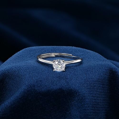 Bague de fiançailles en diamant sur tissu bleu.