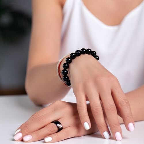 Femme portant un bracelet de perles noires.