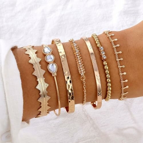 Collection de bracelets en or sur un poignet.