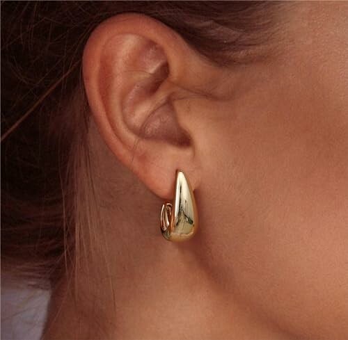 Femme portant une boucle d'oreille en or