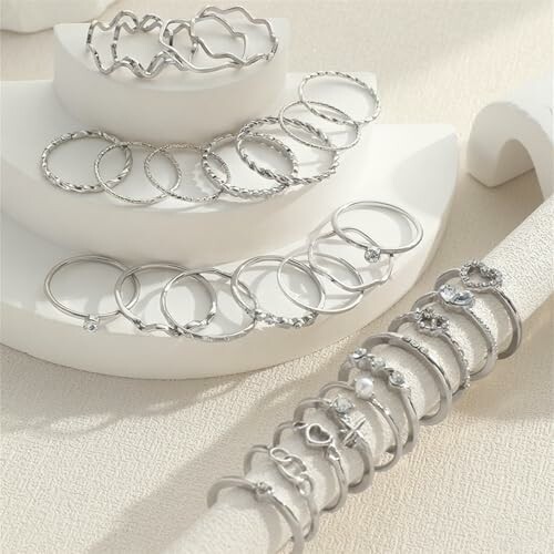 Collection de bagues en argent sur présentoir blanc.