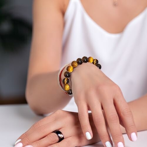 Femme portant un bracelet avec des perles colorées.