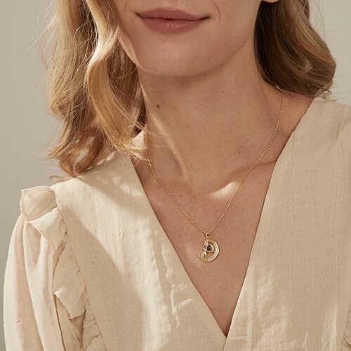 Femme portant un collier en or avec un pendentif lune.