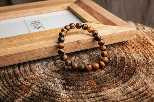 Bracelet en perles de bois sur surface en bois.